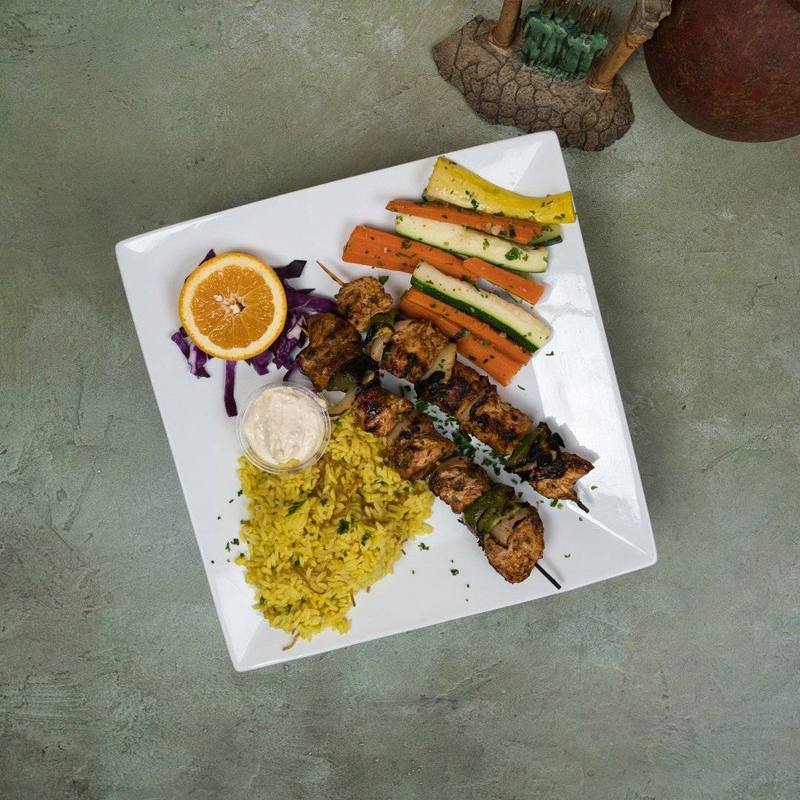 Chicken kebobs with rice pilaf, sauteed carrots and zucchini, and garlic sauce at Phoenician Garden in Fresno