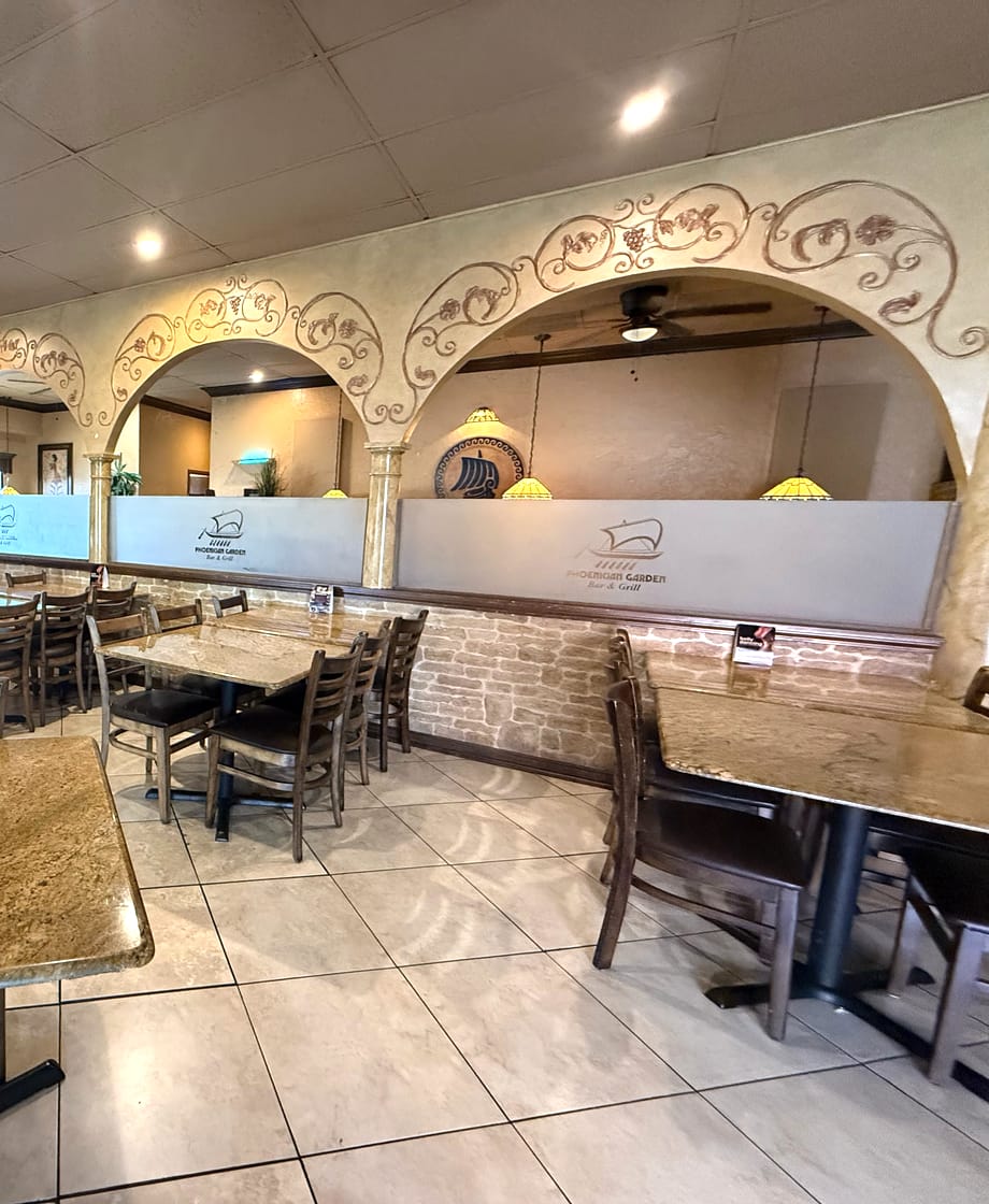 Phoenician Garden dining room tables under painted arches in Fresno