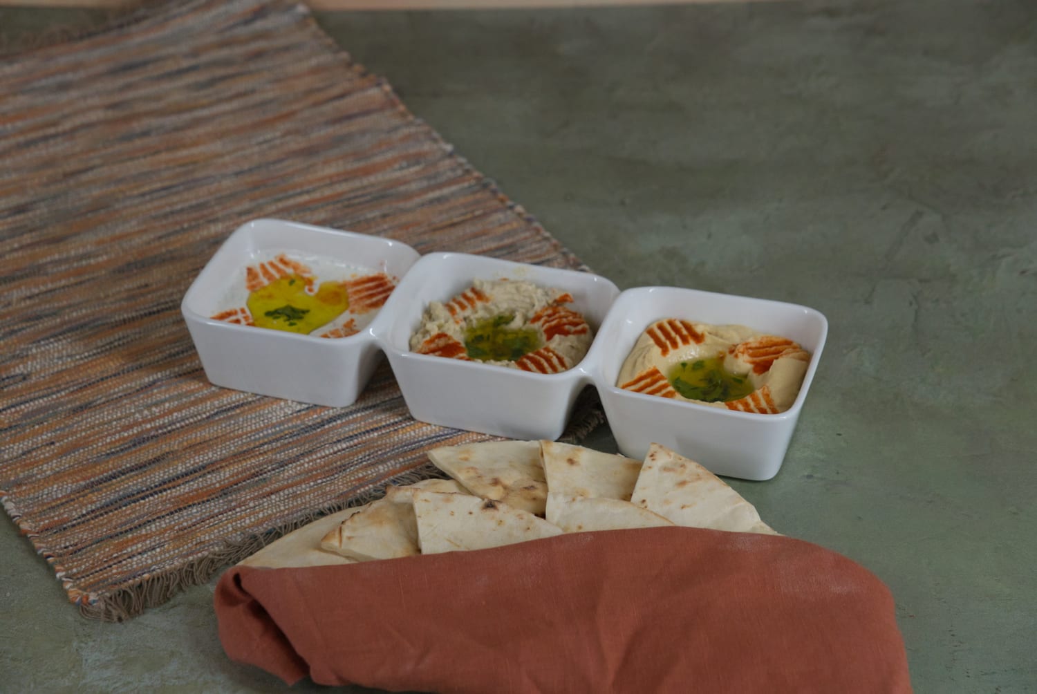 The Flight of Dips at Phoenician Garden in Fresno: house-made hummus, baba ghannouj and labneh served with pita bread