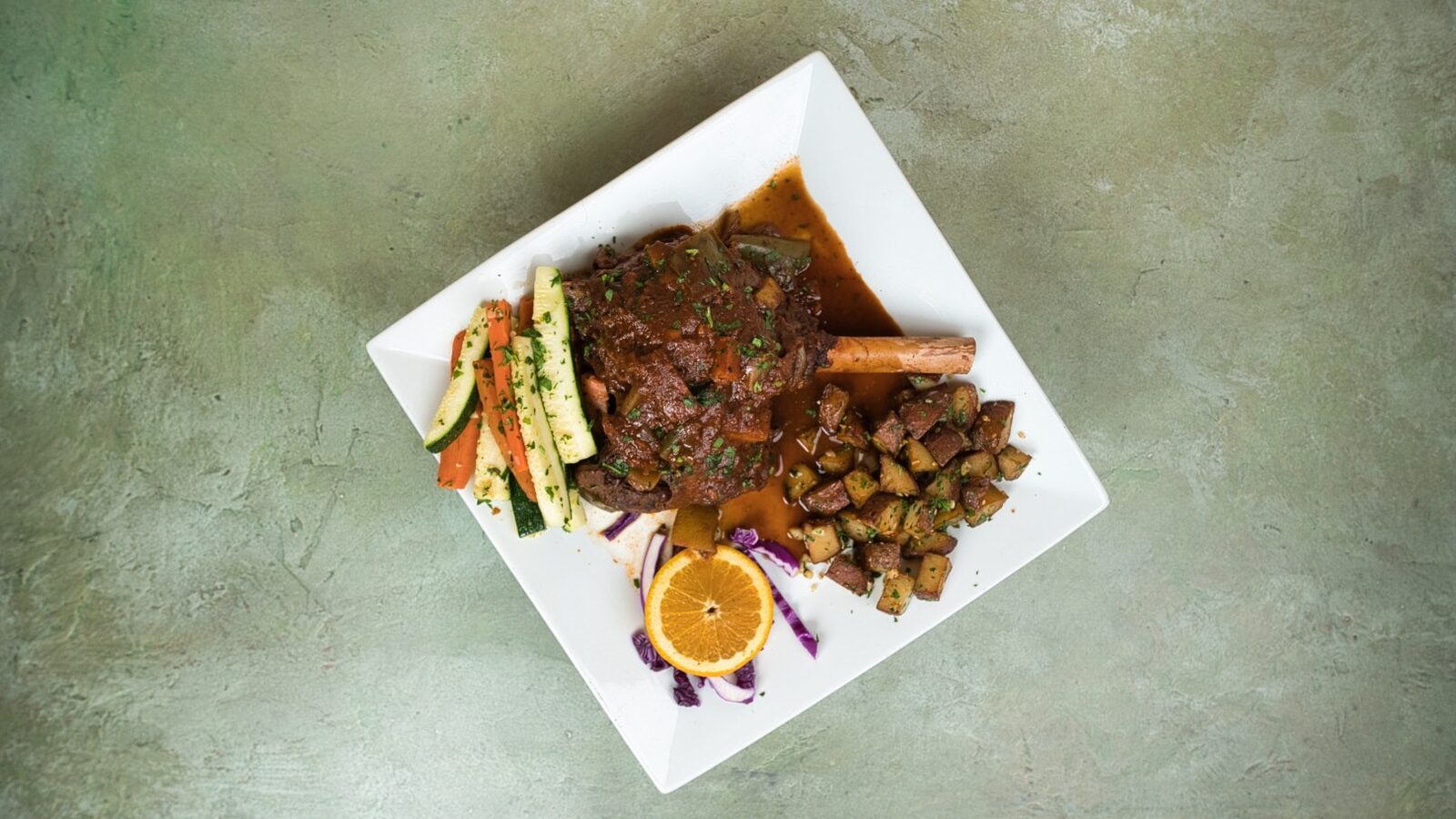 Slow-cooked lamb shank with vegetables at Phoenician Garden Mediterranean Restaurant in Fresno