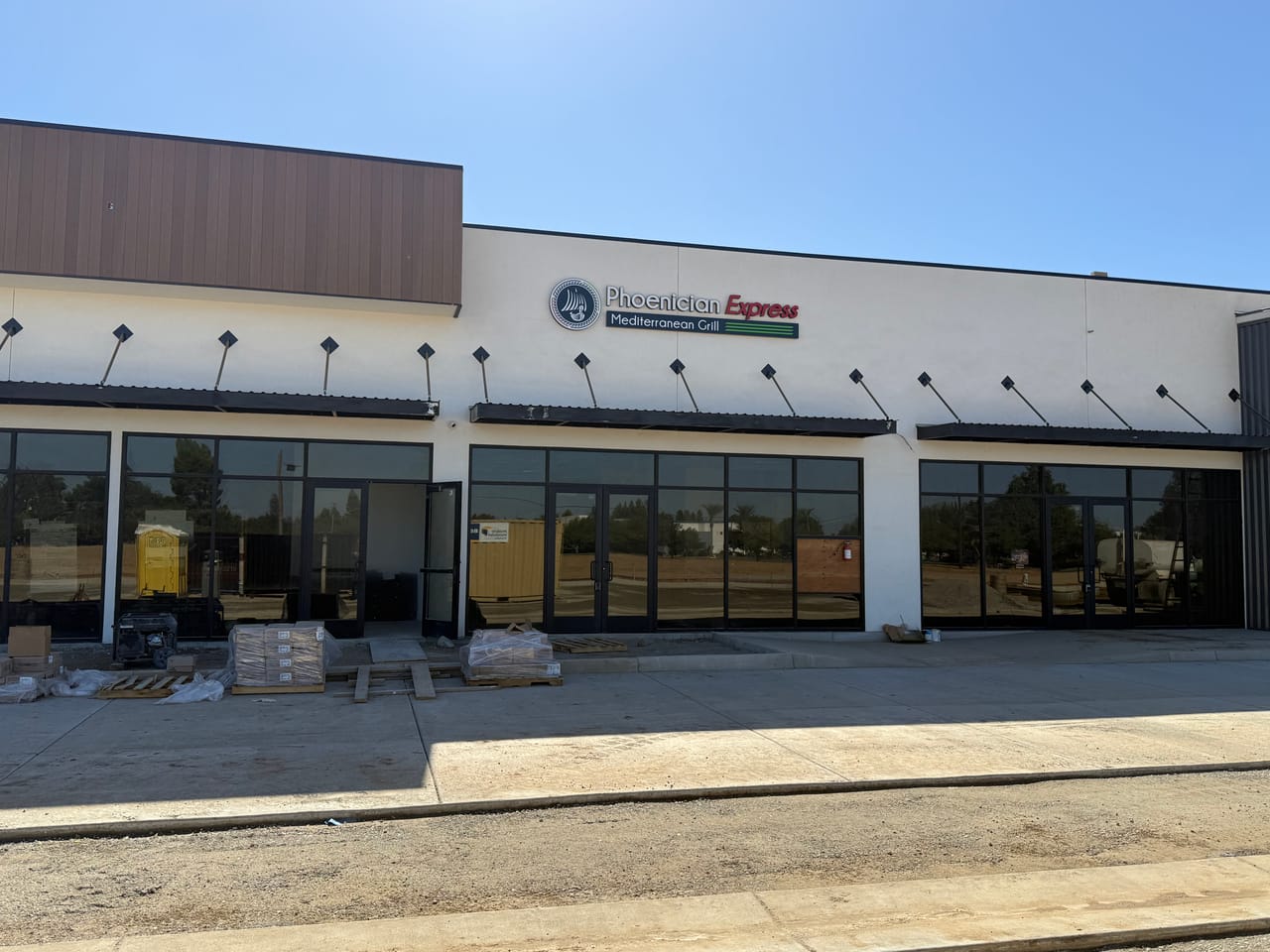 The Phoenician Express Mediterranean Grill sign on the new Clovis storefront at 2605 Owens Mountain Pkwy, with construction still under way