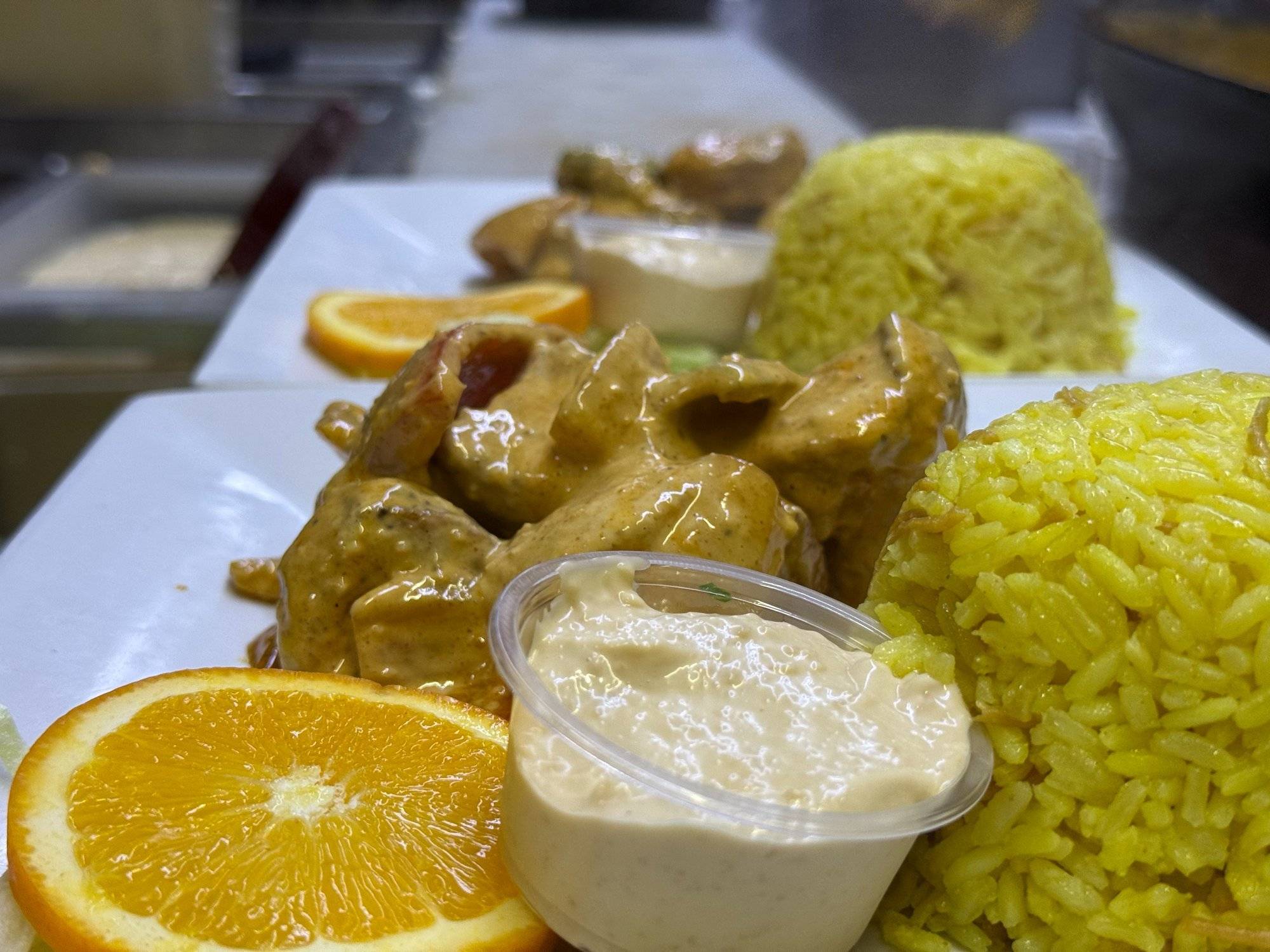 Spicy chicken family feast platter with rice pilaf and sauteed vegetables