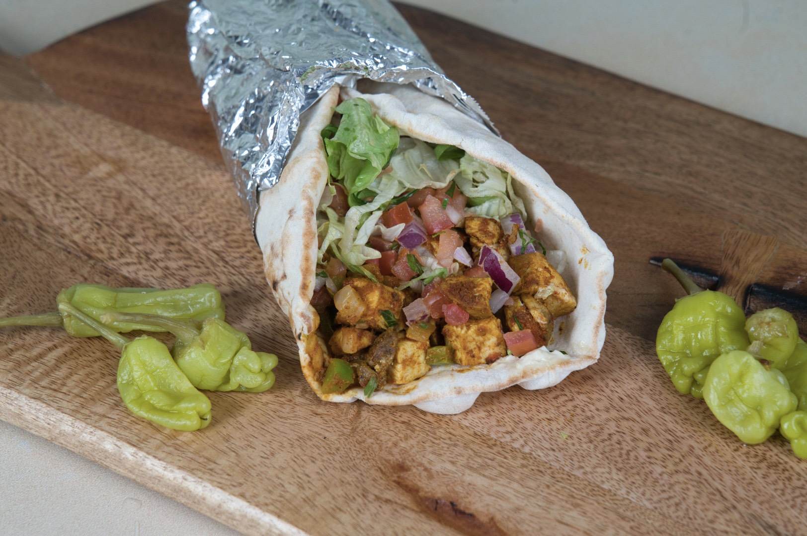 Spicy Chicken Wrap with vegetables and sauce at Phoenician Garden Fresno